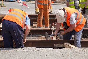 40562532 - railway worker team in the street with a swinging a hammer