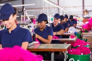 32754657 - group multiracial factory workers sewing in clothing factory